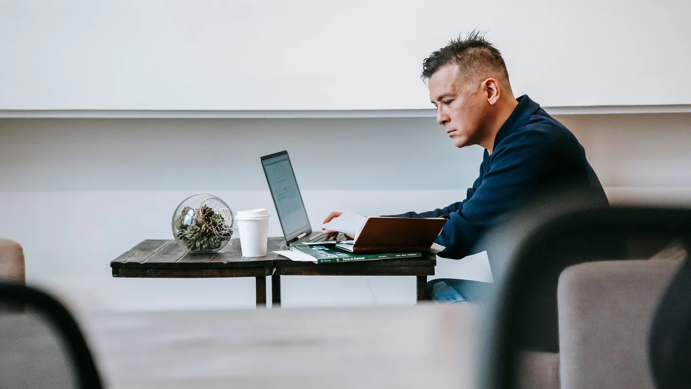 A knowledge worker in focused deep work at a laptop in a calm workspace, depicting the brain's capacity for attention amid constant information overload.