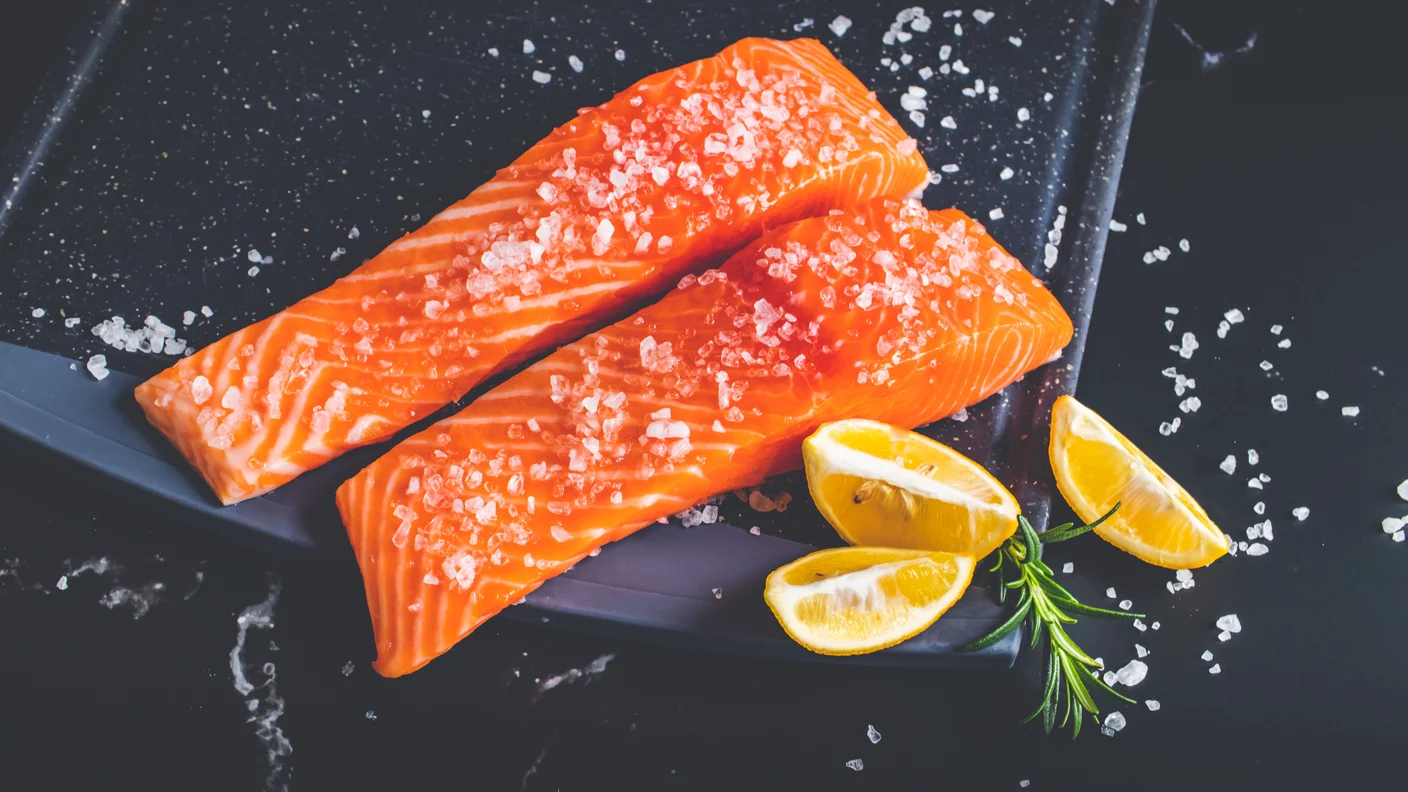 Kultaisia omega-3-kapseleita lusikassa vaaleaa taustaa vasten, EPA ja DHA aivoterveyden ja mielialan tukena vaihdevuosien aikana.